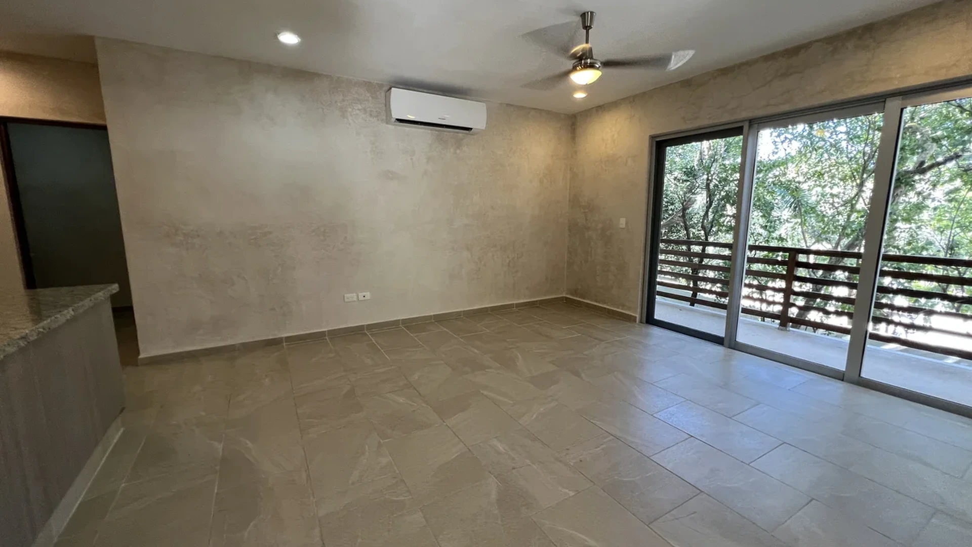 View of Unfurnished Living Space at Carmela, showcasing Spacious Interior, Sliding Glass Doors.