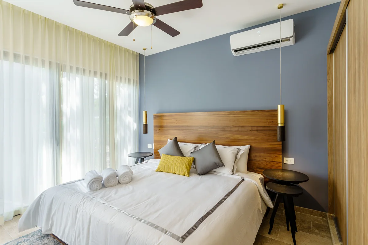 View of Modern Bedroom at Ipana, showcasing Stylish Interior, Wood Headboard.