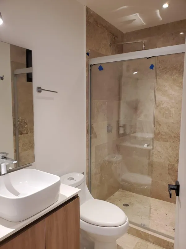 A collection of interior and balcony photos from Lik Xelba, showcasing a finished bedroom with a wooden wardrobe, ceiling fan, air conditioning, and a balcony with a spiral staircase, alongside a modern bathroom with a white sink, toilet, and glas...