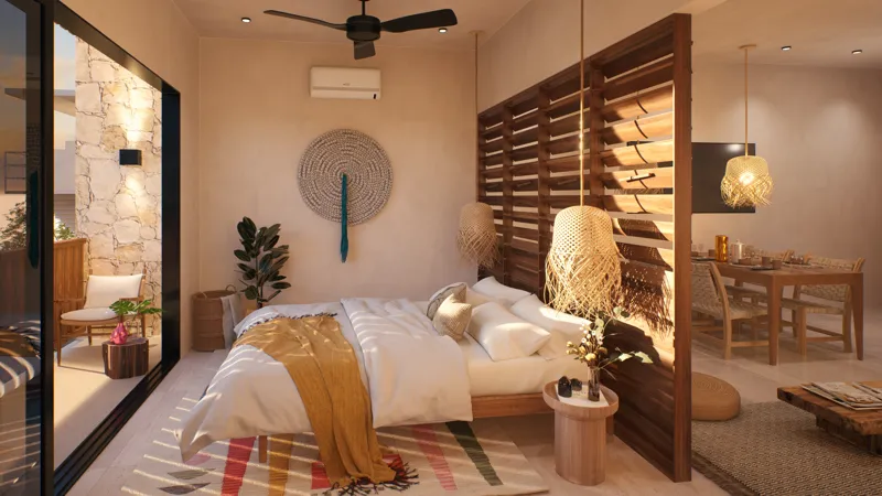 A high-quality render of a Calypso unit interior, showcasing a bedroom with a large bed, white bedding, and a mustard yellow throw, complemented by a ceiling fan and an air conditioning unit. A decorative woven wall hanging and a potted plant enha...