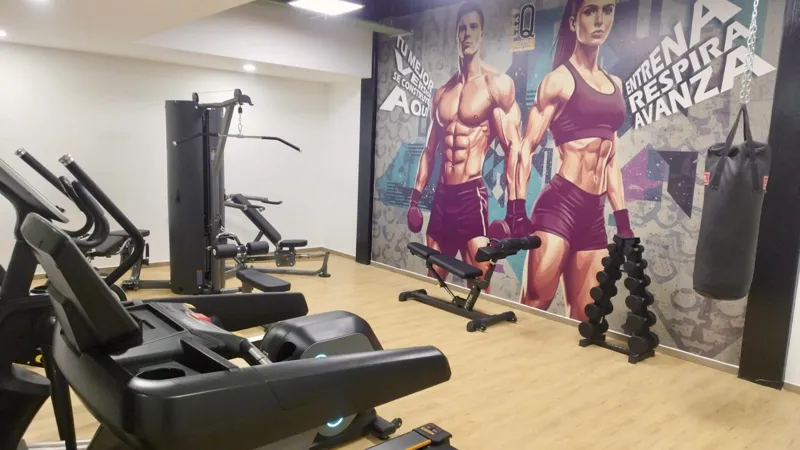 A wide shot of the sparkling rooftop infinity pool at Quartier 75, surrounded by modern lounge chairs and offering panoramic views of the city under a partly cloudy sky.