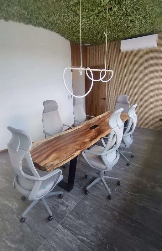 A wide shot of the sparkling rooftop infinity pool at Quartier 75, surrounded by modern lounge chairs and offering panoramic views of the city under a partly cloudy sky.