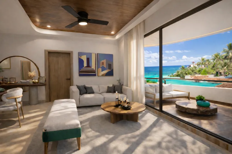 A beautifully rendered modern living room featuring a light-colored sofa, a wooden coffee table, and a ceiling fan, with a large sliding glass door opening to a balcony that offers a panoramic view of the turquoise Caribbean Sea and lush palm trees.