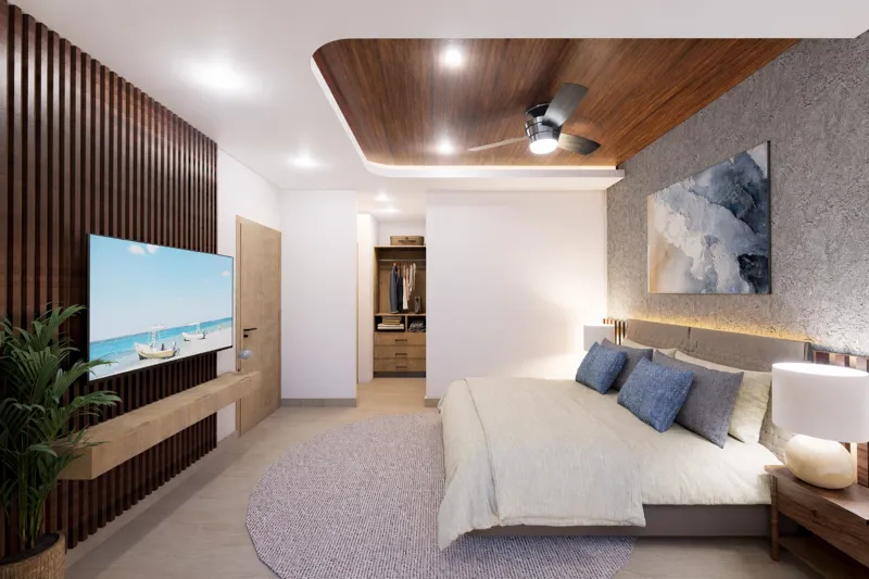 A beautifully rendered modern living room featuring a light-colored sofa, a wooden coffee table, and a ceiling fan, with a large sliding glass door opening to a balcony that offers a panoramic view of the turquoise Caribbean Sea and lush palm trees.