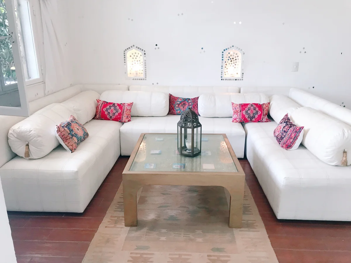 View of Living Room at Casa Dragonfly, showcasing White Sectional Sofa, Moroccan Decor.