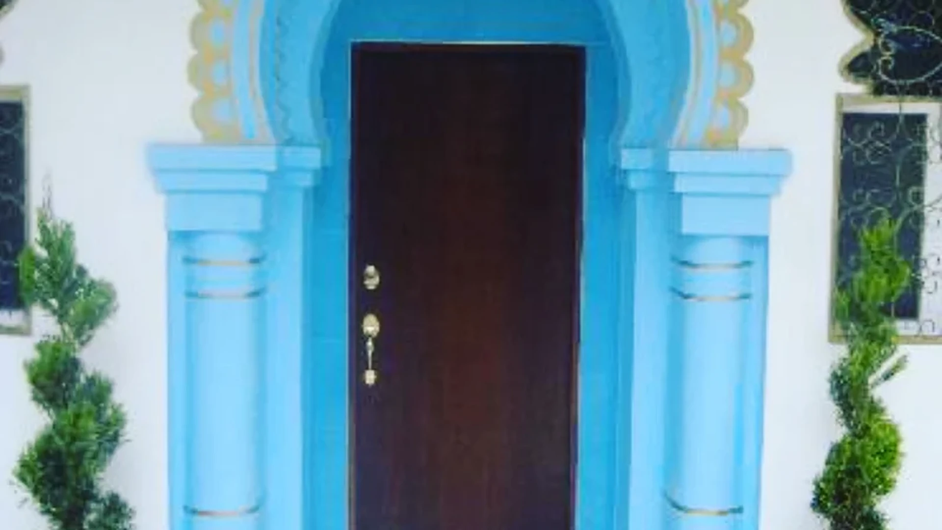 View of Residential Entrance at Casa Dragonfly, showcasing Distinctive Front Door, Blue Archway.