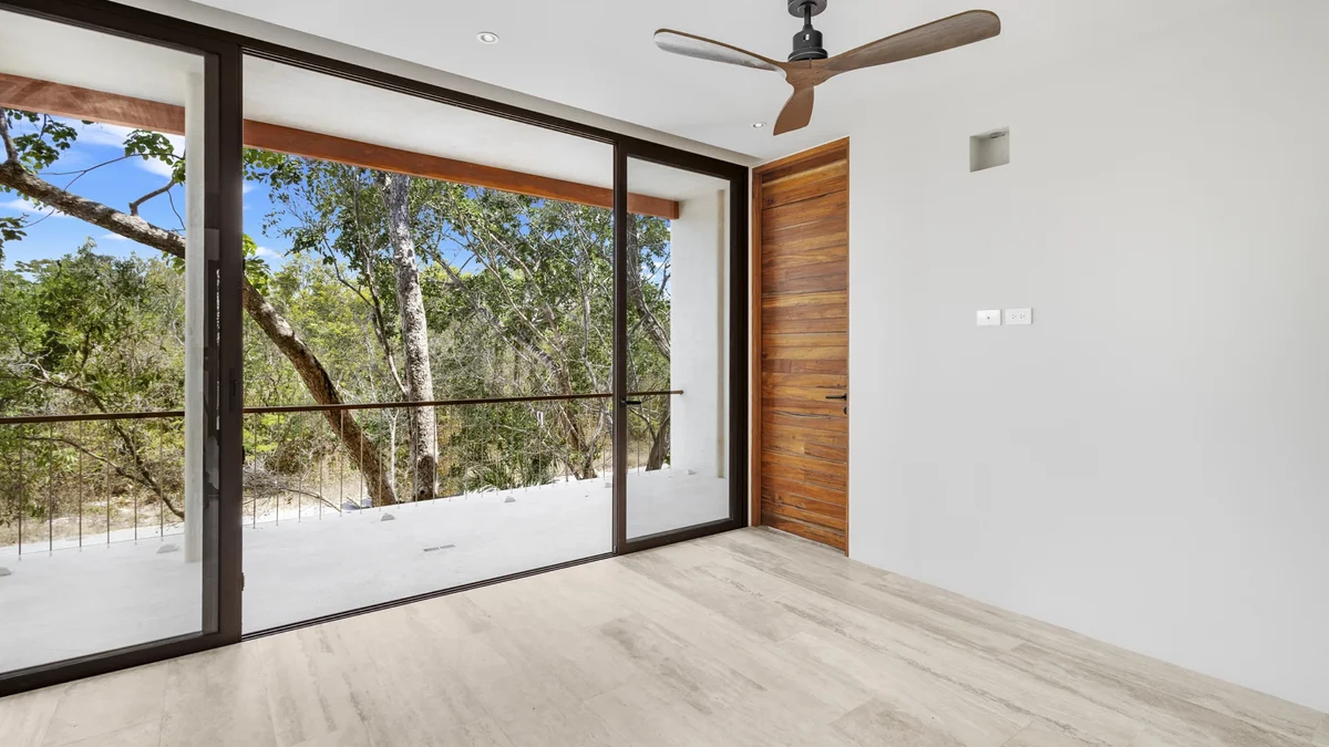 View of Unfurnished Room at Casa Kaa, showcasing Modern Interior, Sliding Glass Doors.