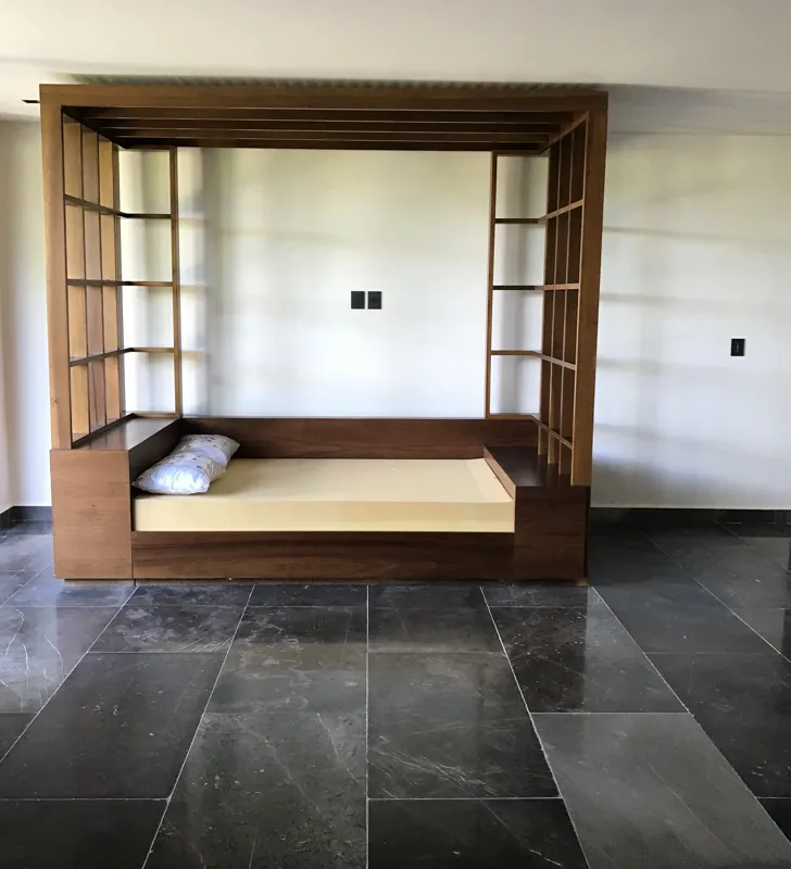 A series of interior photographs from Humana's finished model units, featuring dark grey tiled floors, white walls, wooden built-in furniture, a modern kitchen with stainless steel appliances, and balconies offering views of lush tropical vegetation.