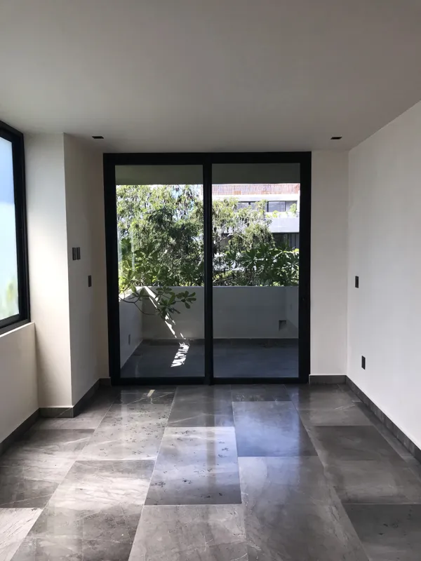 A collection of interior photos from Humana development, featuring a modern bathroom with a unique stone vessel sink, dark wood vanity, and rain shower, alongside a spacious living area with polished grey tiled floors, white walls, and large slidi...