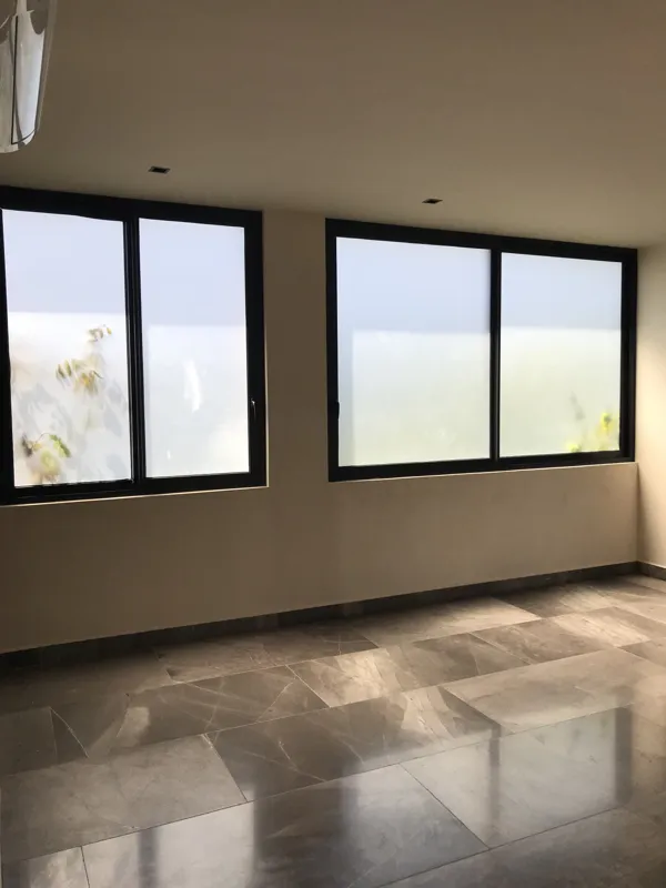 A collection of interior photos from Humana development, featuring a modern bathroom with a unique stone vessel sink, dark wood vanity, and rain shower, alongside a spacious living area with polished grey tiled floors, white walls, and large slidi...