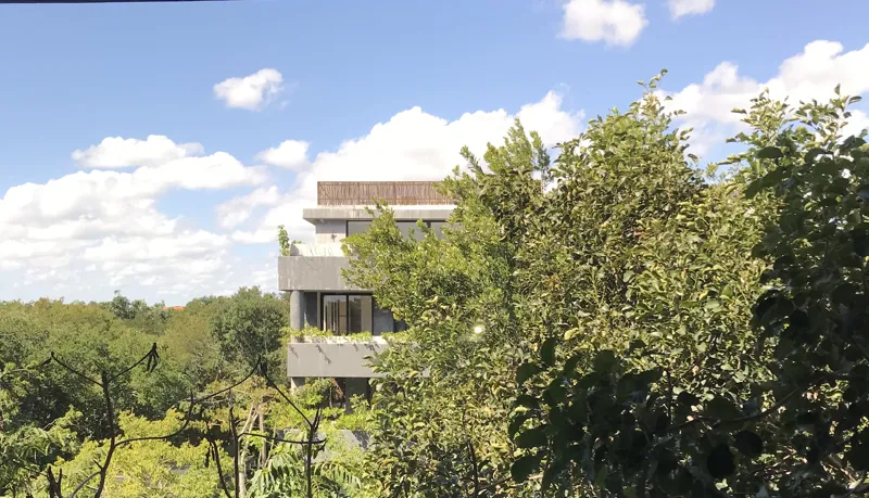 A collection of interior photos from Humana development, featuring a modern bathroom with a unique stone vessel sink, dark wood vanity, and rain shower, alongside a spacious living area with polished grey tiled floors, white walls, and large slidi...