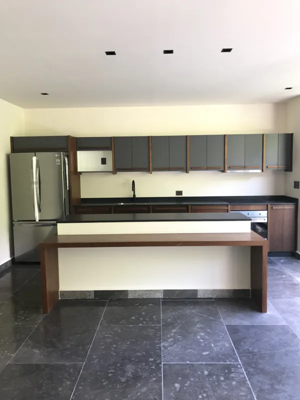 A series of high-resolution photographs displaying the completed interiors and private outdoor spaces of Humana's residential units. Images include a contemporary kitchen with dark grey and wood cabinets, a large island, and stainless steel applia...