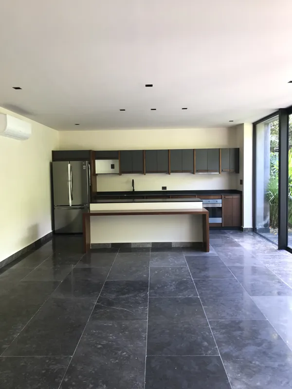 A series of high-resolution photographs displaying the completed interiors and private outdoor spaces of Humana's residential units. Images include a contemporary kitchen with dark grey and wood cabinets, a large island, and stainless steel applia...