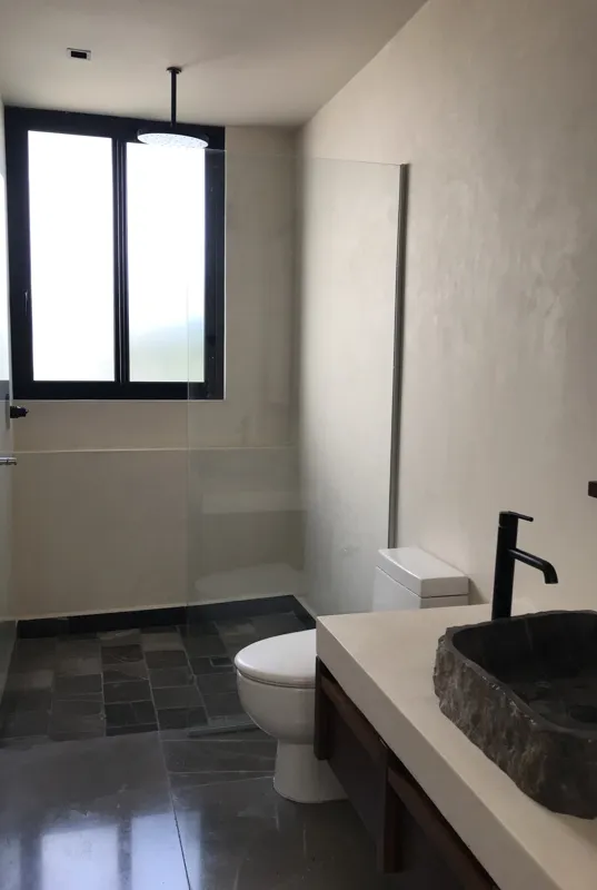 A series of eight photographs depicting the finished interiors and private rooftop amenities of a residential unit within the Humana development in Tulum. Images include a spacious living area with dark tiled floors and large glass doors, a modern...