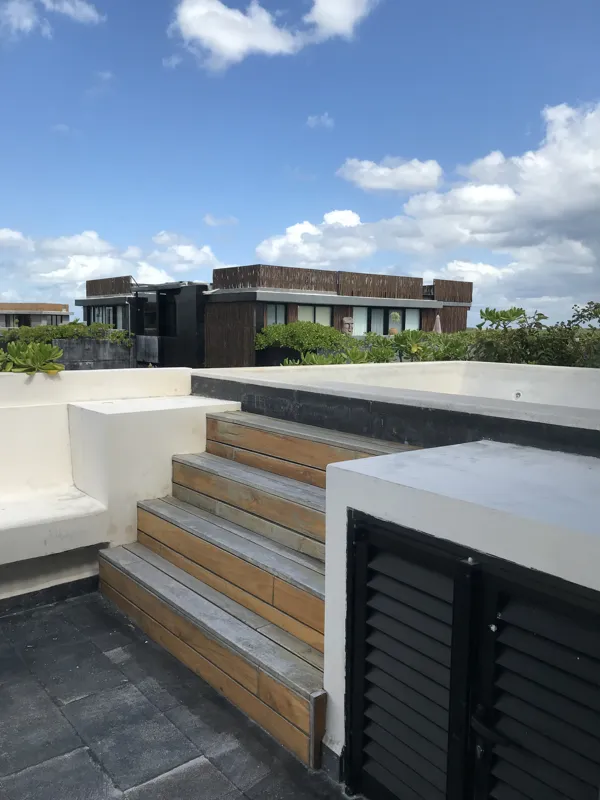 A series of eight photographs depicting the finished interiors and private rooftop amenities of a residential unit within the Humana development in Tulum. Images include a spacious living area with dark tiled floors and large glass doors, a modern...