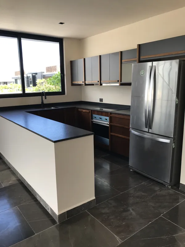 A series of eight photographs depicting the finished interiors and private rooftop amenities of a residential unit within the Humana development in Tulum. Images include a spacious living area with dark tiled floors and large glass doors, a modern...