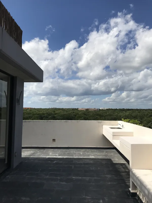 A series of eight photographs depicting the finished interiors and private rooftop amenities of a residential unit within the Humana development in Tulum. Images include a spacious living area with dark tiled floors and large glass doors, a modern...