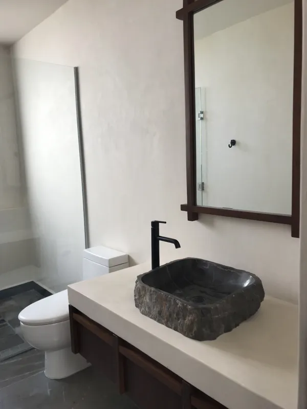 A series of eight photographs depicting the finished interiors and private rooftop amenities of a residential unit within the Humana development in Tulum. Images include a spacious living area with dark tiled floors and large glass doors, a modern...