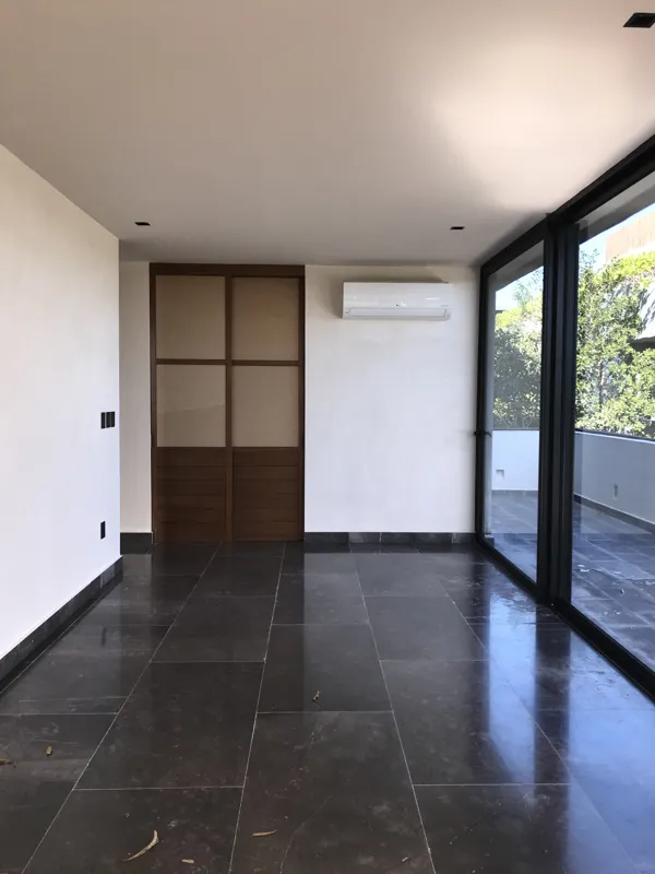 A collection of images showcasing the finished interiors of a Humana model unit, including a contemporary kitchen with dark cabinets and an island, a living area with dark marble floors and a built-in wooden daybed, and a bathroom with a unique st...