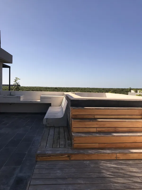 A collection of images showcasing the finished interiors of a Humana model unit, including a contemporary kitchen with dark cabinets and an island, a living area with dark marble floors and a built-in wooden daybed, and a bathroom with a unique st...