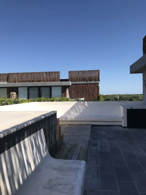 A collection of images showcasing the finished interiors of a Humana model unit, including a contemporary kitchen with dark cabinets and an island, a living area with dark marble floors and a built-in wooden daybed, and a bathroom with a unique st...