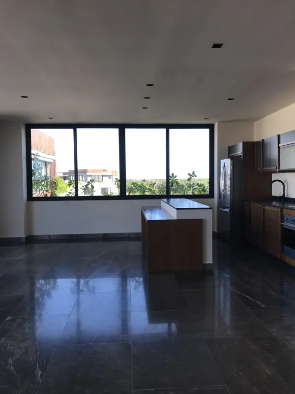 A collection of images showcasing the finished interiors of a Humana model unit, including a contemporary kitchen with dark cabinets and an island, a living area with dark marble floors and a built-in wooden daybed, and a bathroom with a unique st...