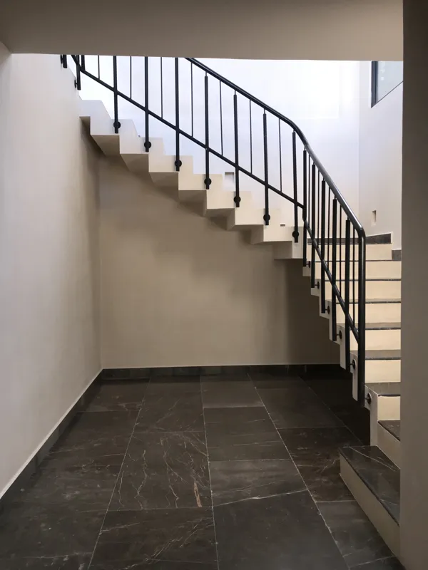 A collection of images showcasing the finished interiors of a Humana model unit, including a contemporary kitchen with dark cabinets and an island, a living area with dark marble floors and a built-in wooden daybed, and a bathroom with a unique st...