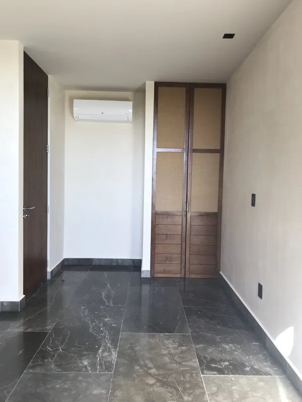 A luxurious rooftop terrace at Humana featuring a built-in jacuzzi with wooden steps, surrounded by modern architecture and lush greenery under a clear blue sky, showcasing finished outdoor amenities.