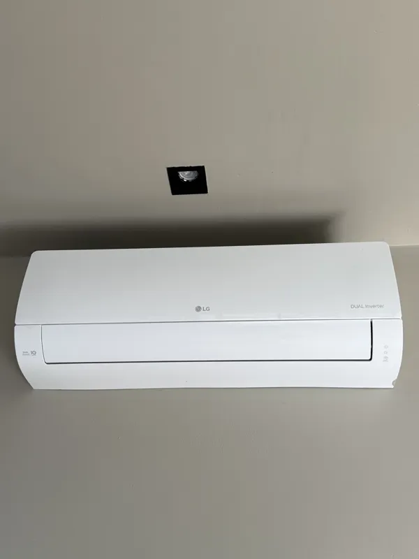 A close-up shot of a modern, brushed brass gooseneck faucet with a single lever handle, set against a dark, speckled countertop and a dark grey backsplash, indicating high-quality interior finishes in an Arthouse Signature apartment.