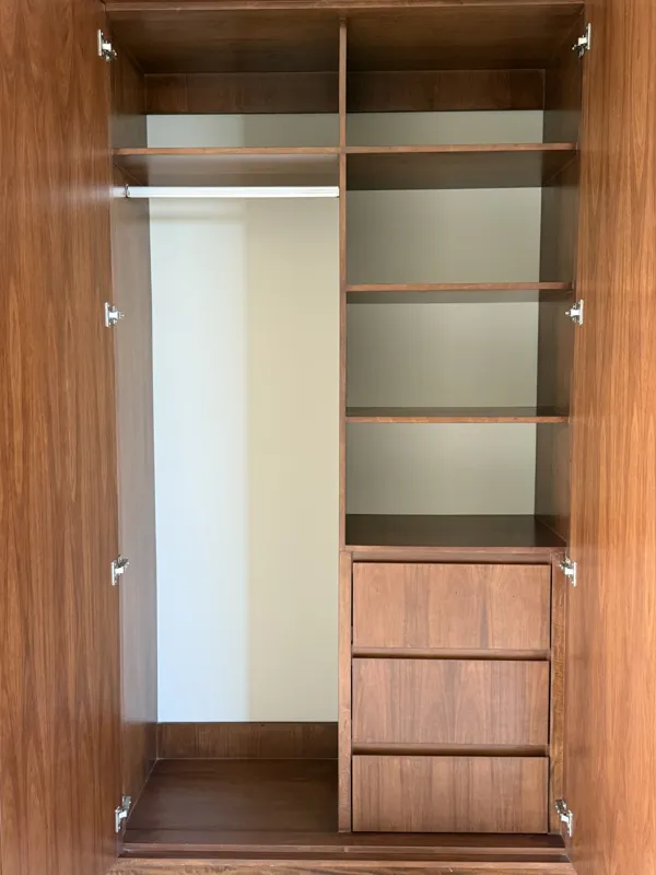 A close-up shot of a modern, brushed brass gooseneck faucet with a single lever handle, set against a dark, speckled countertop and a dark grey backsplash, indicating high-quality interior finishes in an Arthouse Signature apartment.