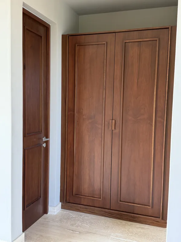 A close-up shot of a modern, brushed brass gooseneck faucet with a single lever handle, set against a dark, speckled countertop and a dark grey backsplash, indicating high-quality interior finishes in an Arthouse Signature apartment.