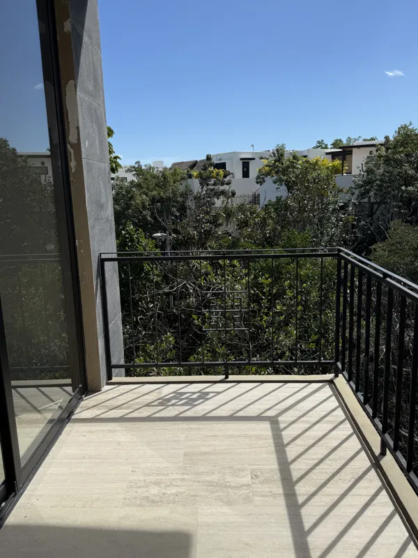 A close-up shot of a modern, brushed brass gooseneck faucet with a single lever handle, set against a dark, speckled countertop and a dark grey backsplash, indicating high-quality interior finishes in an Arthouse Signature apartment.