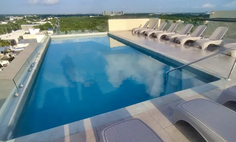 A collection of interior and exterior photographs showcasing the finished common areas and amenities of Quartier 75, including a stylish lobby lounge with contemporary furniture, a fully equipped modern gym with various exercise machines, a serene...