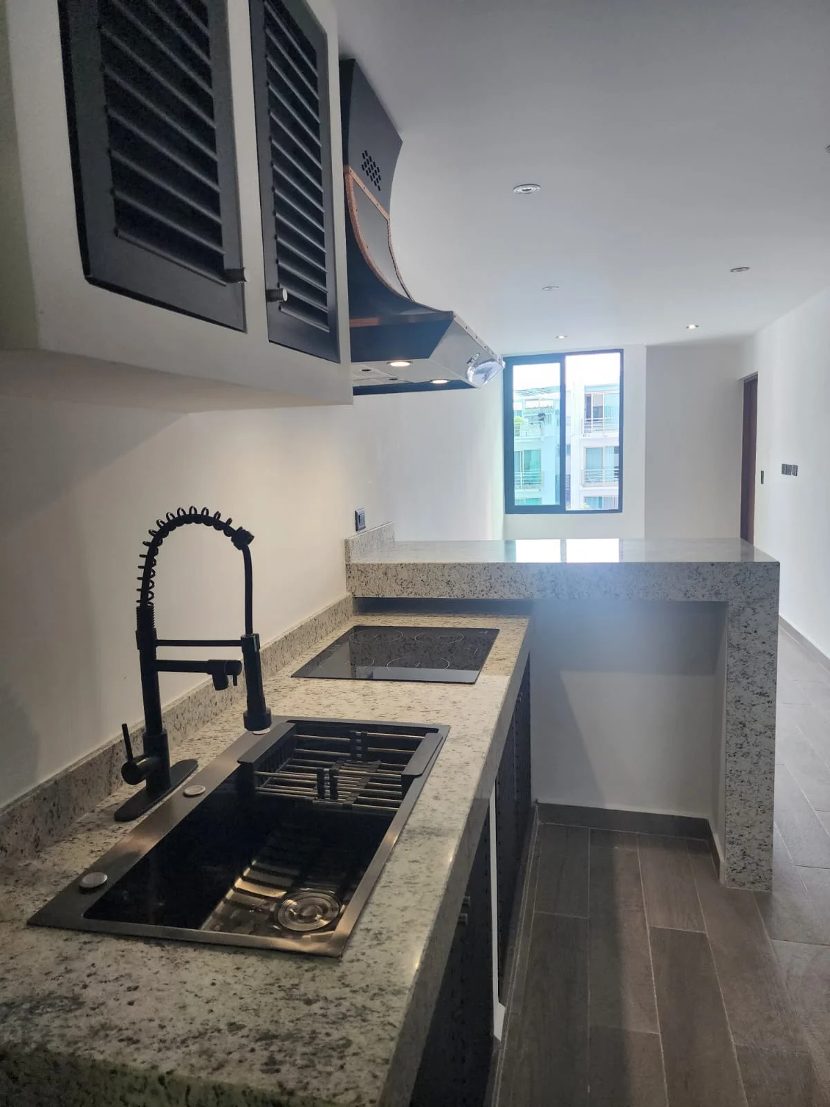 View of Modern Kitchen at Serenata, showcasing Granite Countertops, Stainless Steel Sink.