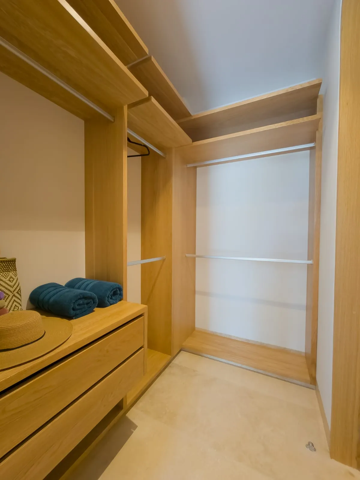 Walk-in closet with wooden shelving and drawers