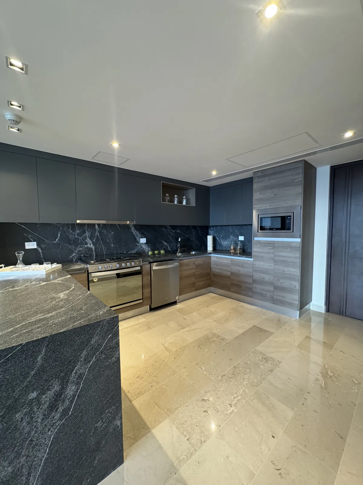 Modern kitchen with dark cabinets and marble island