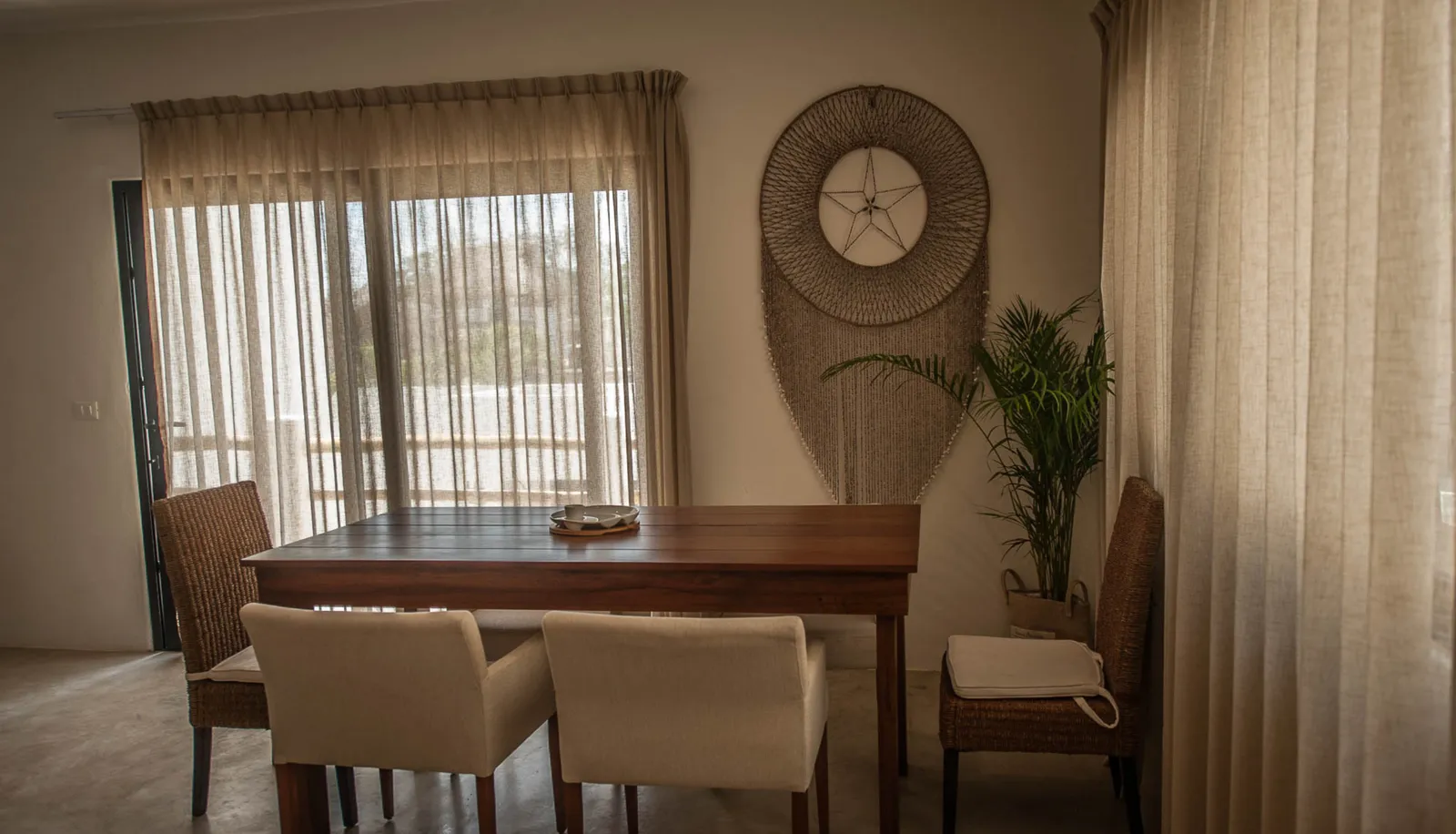 Dining room with wooden table and macrame wall art