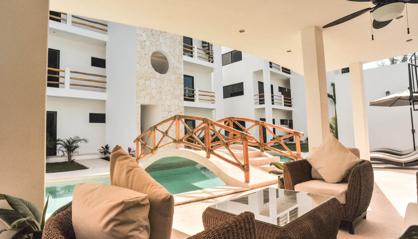 Pool area with wooden bridge and lounge seating