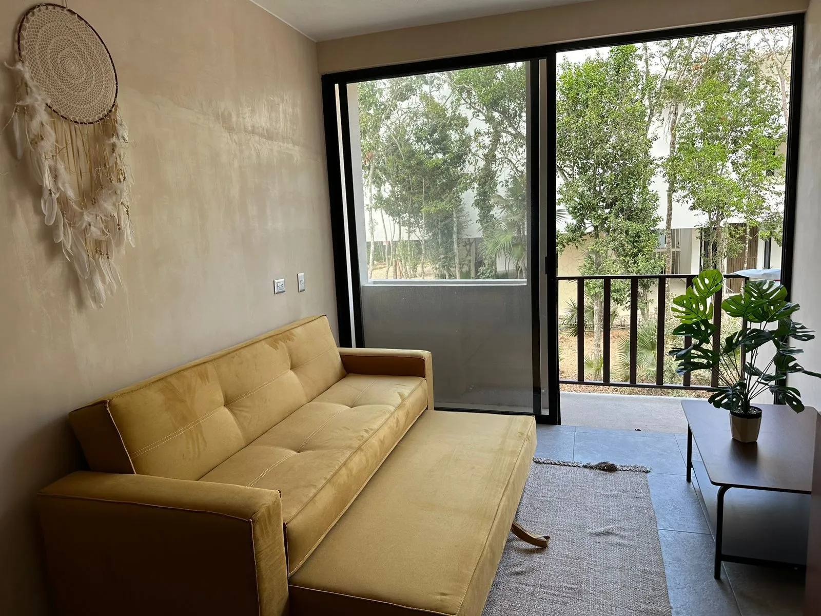 Living room with yellow sofa and balcony view