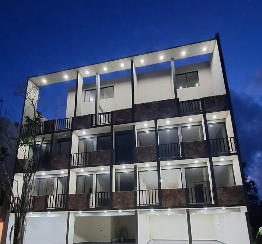 Modern white building exterior with balconies at night