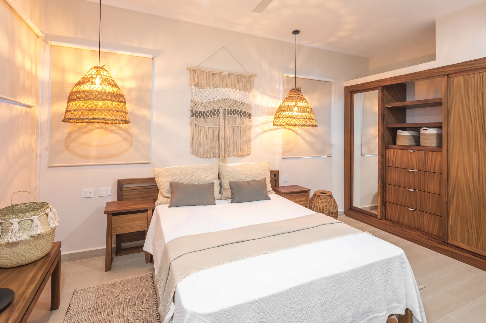 A bedroom with wooden furniture and woven pendant lights.