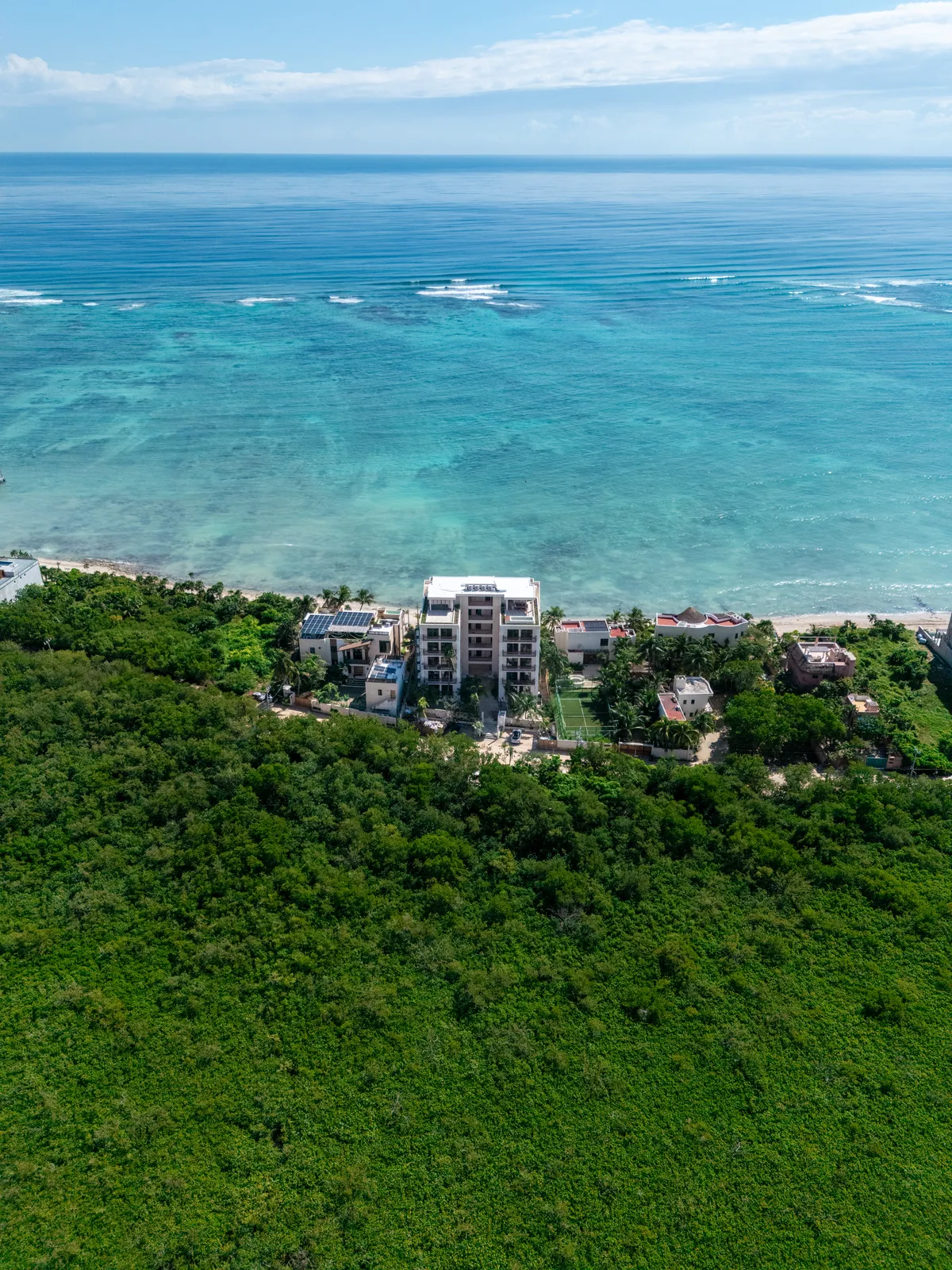 Aerial view of white beachfront buildings near turquoise ocean
