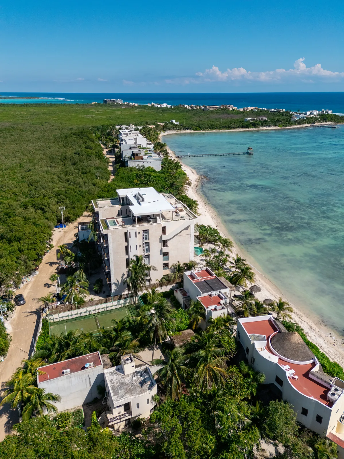 Aerial view of beachfront buildings and tennis court
