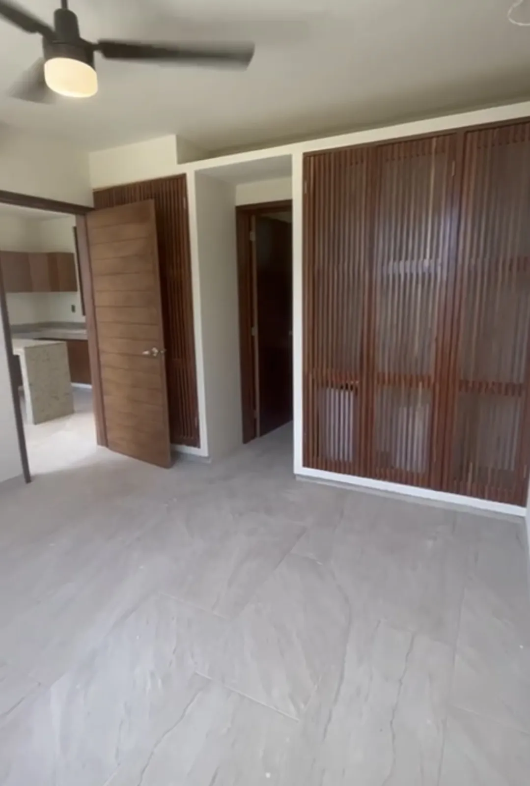 Finished interior room with wooden cabinetry and ceiling fan