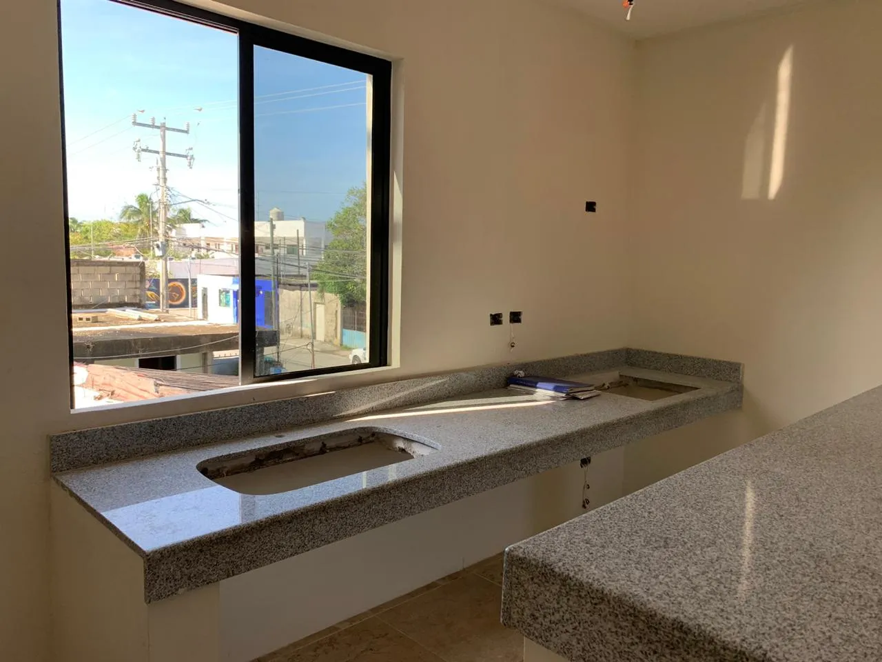 Unfinished kitchen area with granite countertop and window