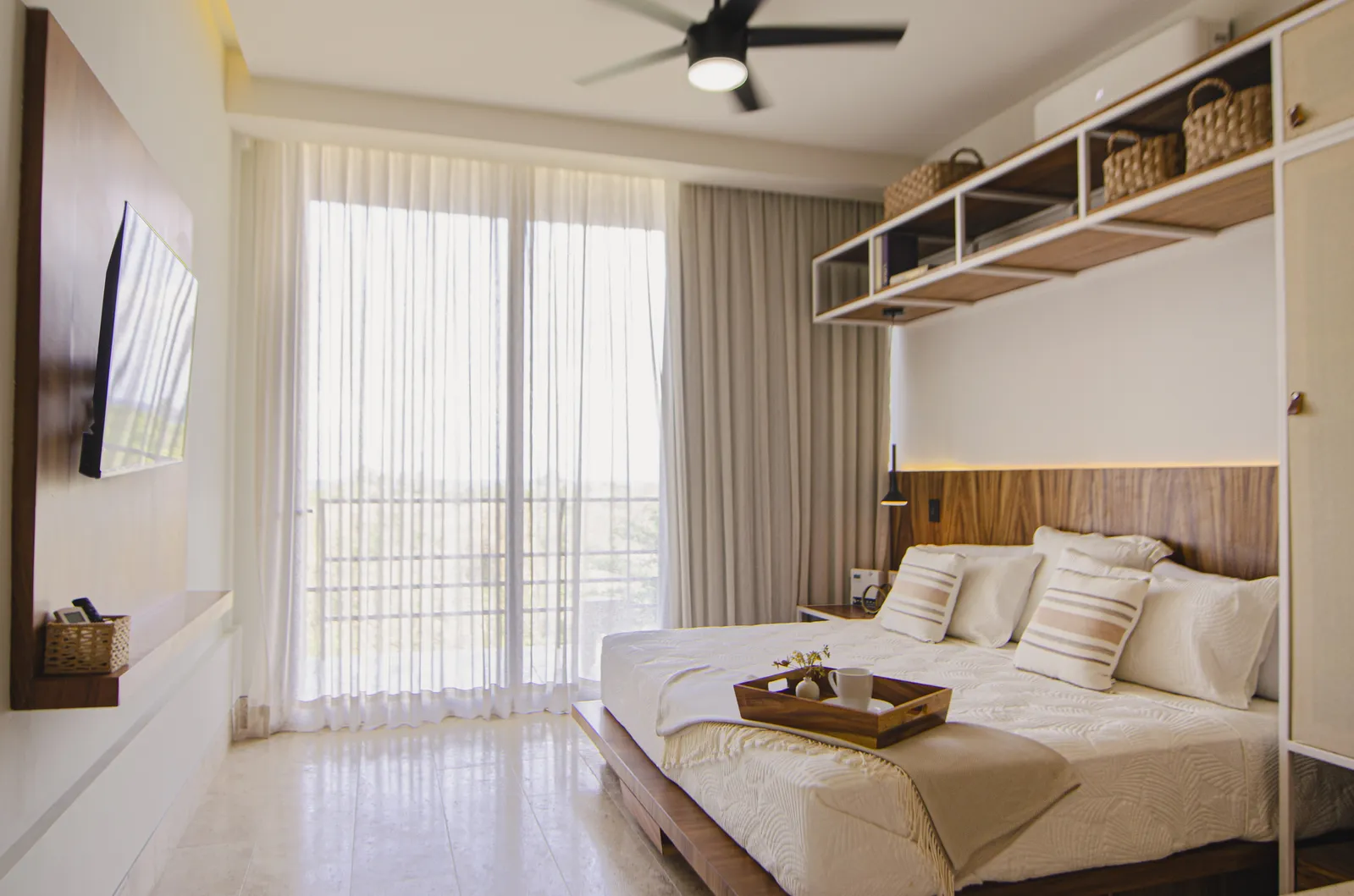 Bright bedroom with white linens and wooden accents
