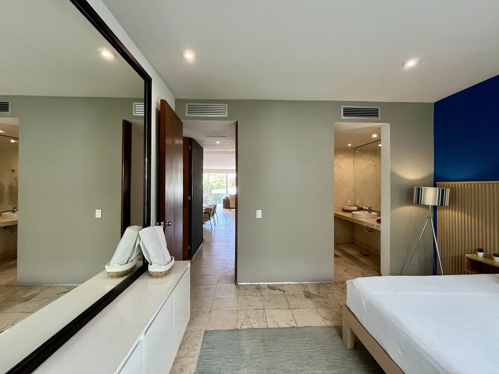 Modern bedroom with blue accent wall and marble bathroom