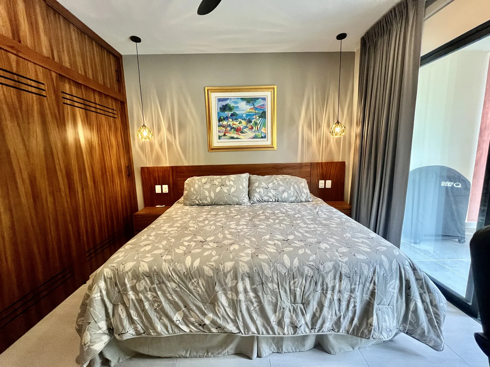 Furnished bedroom with bed, wardrobe, and balcony access