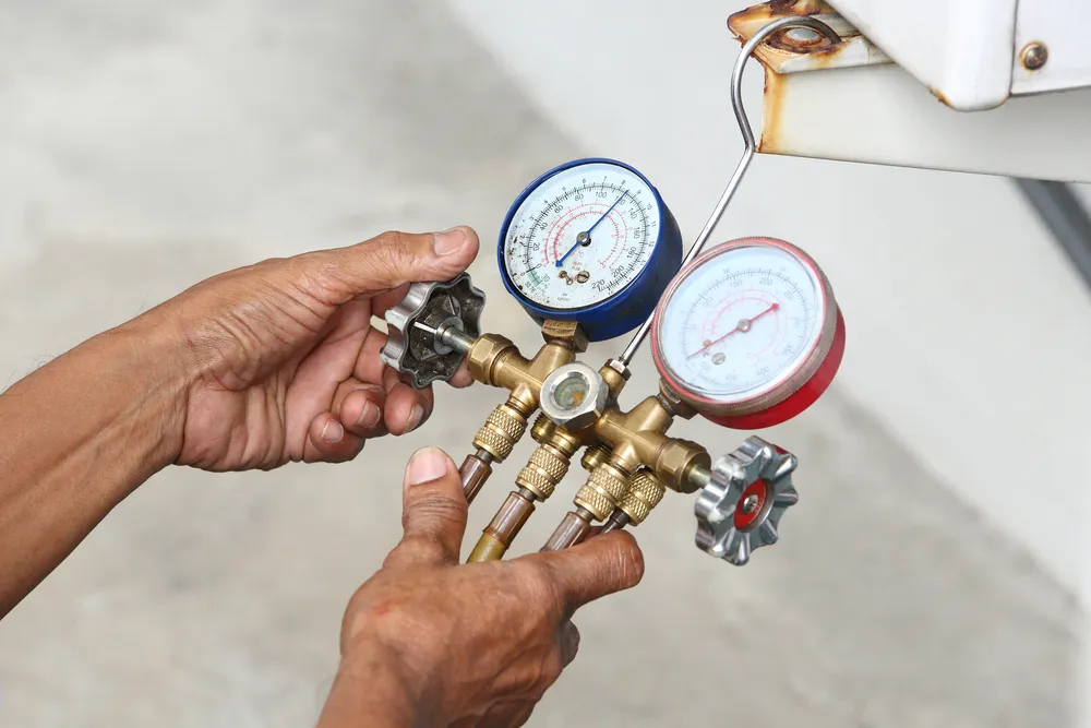 A mans hands turning the handle of a gas controller