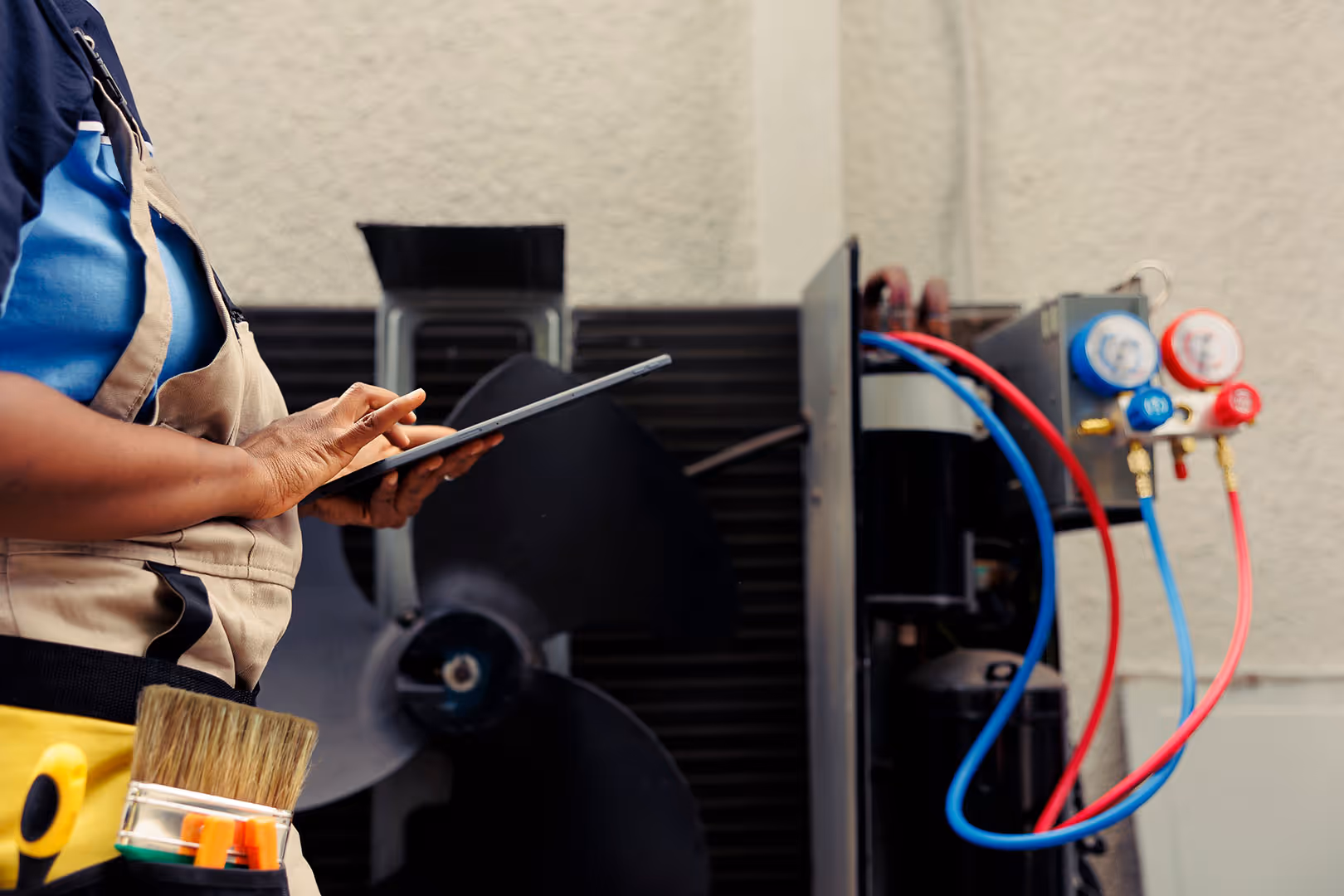 A person with an iPad reviewing gas controls on a refrigeration device